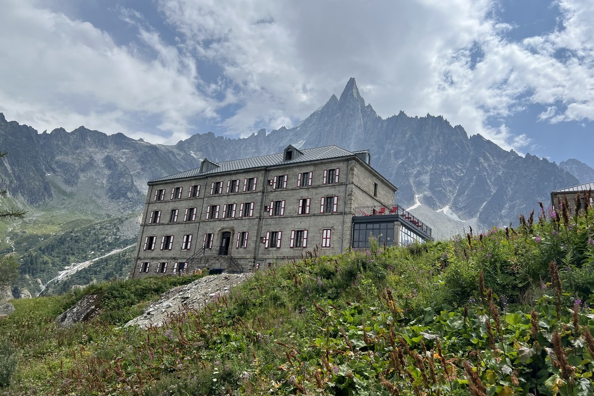 A mountain rifugio below a high rocky peak