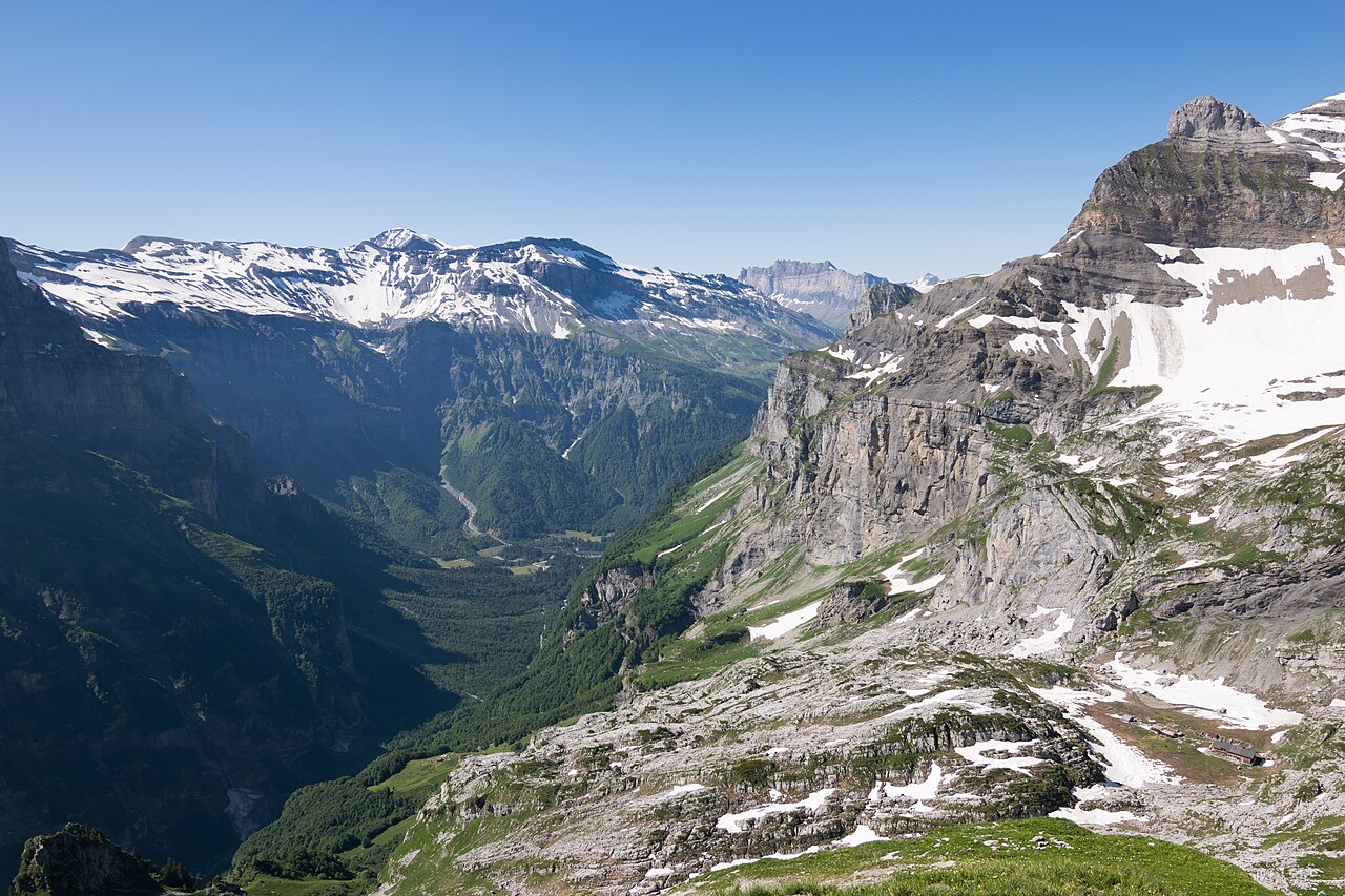 A green valley running between limestone walls in the Sixt-Passy reserve, with an alpage on the shelf above it.
